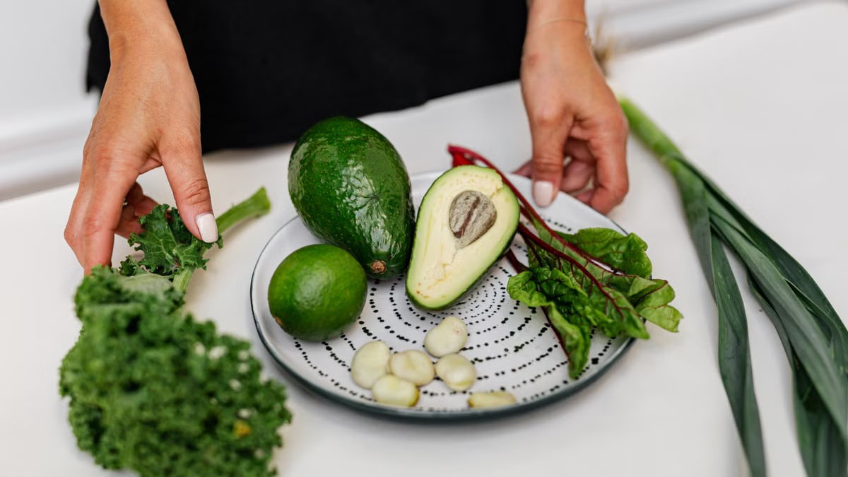 Top view of assorted fresh ingredients including avocado and kale on a plate. Perfect for healthy eating themes.